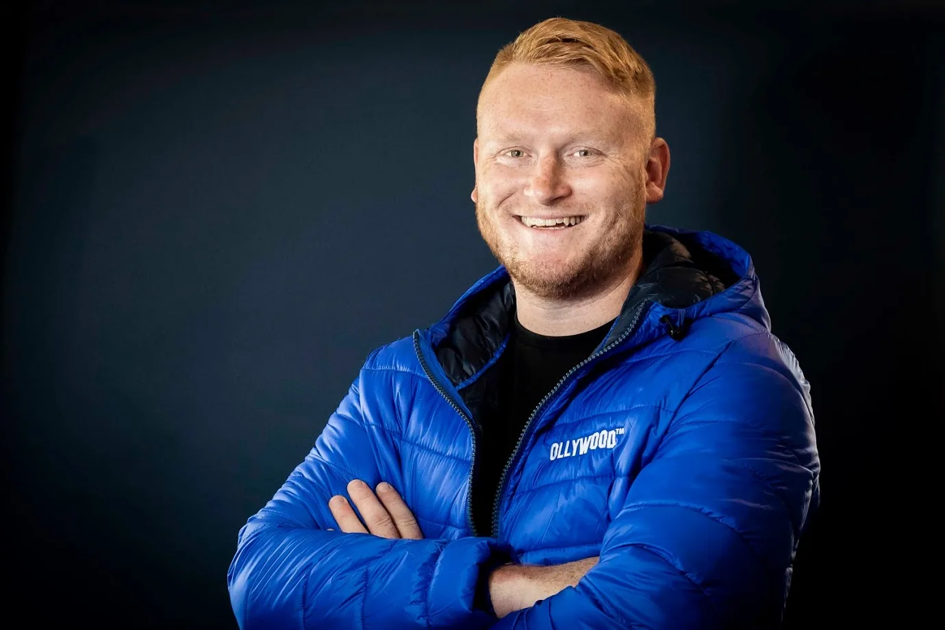 Oli Williams, founder of OLLYWOOD, wearing a blue OLLYWOOD jacket