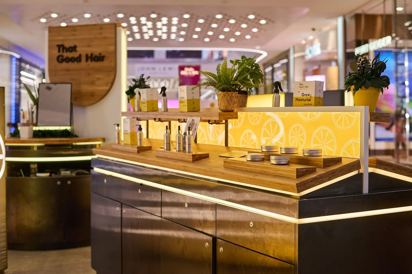 That Good Hair specialist hair products retail kiosk at Westfield London with illuminated timber counter, built by OLLYWOOD