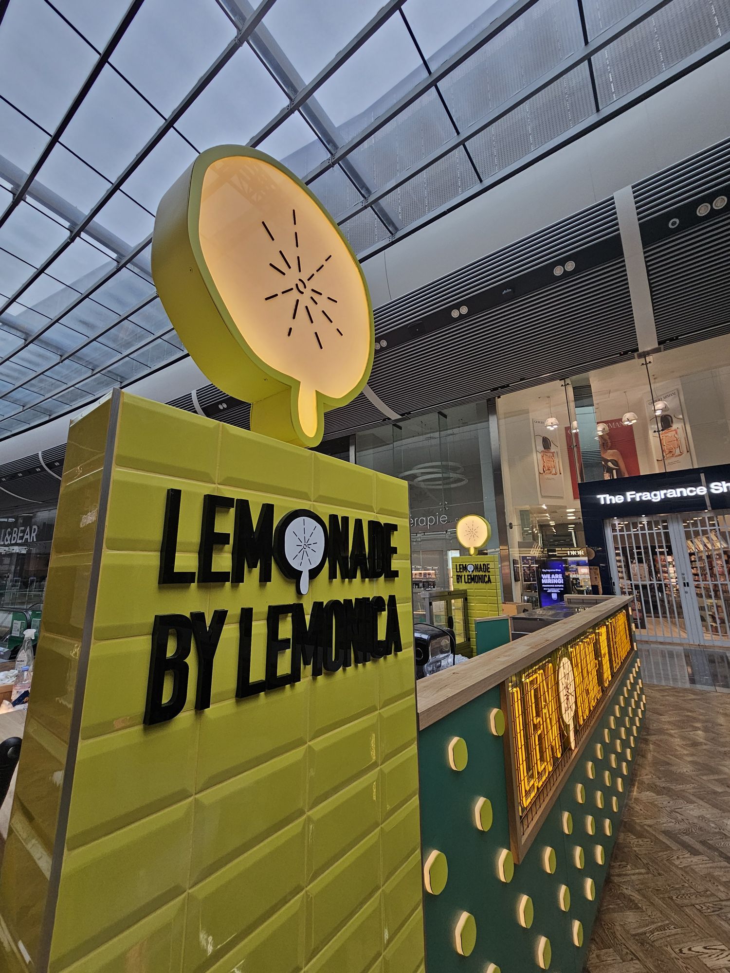 Completed Lemonica lemonade kiosk with illuminated lemon totem at Westfield Stratford