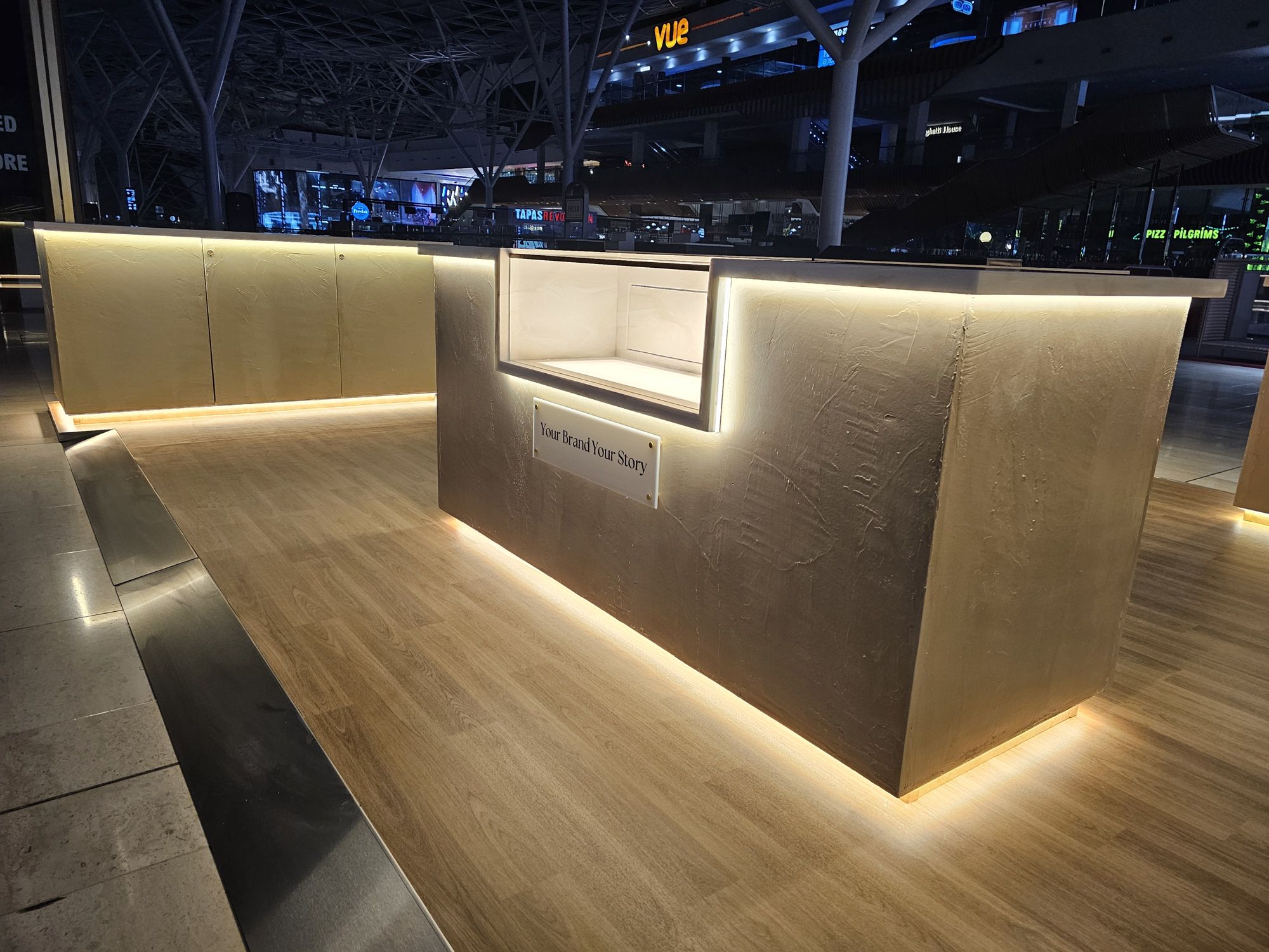 Your Brand Your Story display counter with recessed brand plate and open display bay, built by OLLYWOOD
